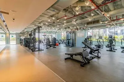 a gym with several treadmills and exercise machines at Vogue Downtown Mag 318 near Burj Khalifa and Dubai Mall, Studio Apartment with Balcony and City View, Access to all Amenities in Dubai