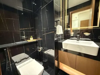 a bathroom with a white toilet and a sink at Sky High Premium 1BR with Stunning Views in Dubai