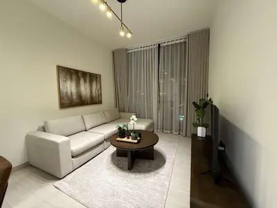 a living room with a white couch and a table at Sky High Premium 1BR with Stunning Views in Dubai