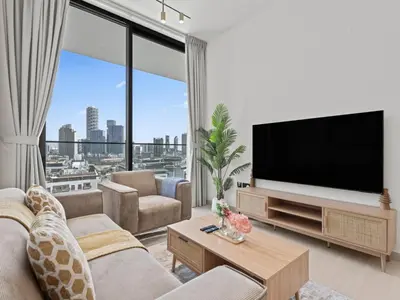 a living room with a tv and a large window at Aesthetic Elegance 1BDR in Binghatti Onyx in Dubai