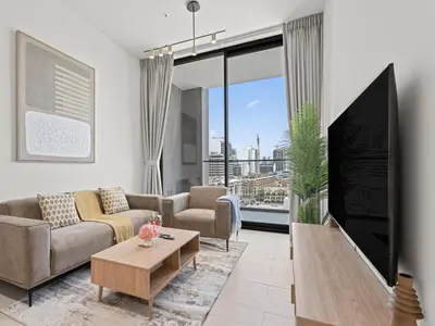 a living room with a couch and a tv at Aesthetic Elegance 1BDR in Binghatti Onyx in Dubai