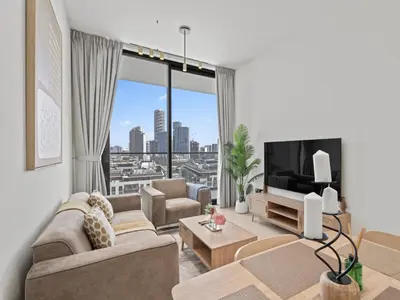 a living room with a couch and a tv at Aesthetic Elegance 1BDR in Binghatti Onyx in Dubai