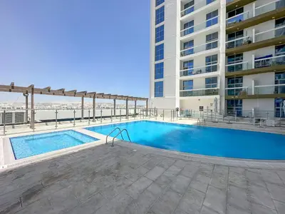 a swimming pool in front of a building at Modern Studio In Al-Furjan close to Metro-15 in Dubai