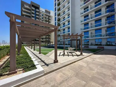 a group of wooden shelters in front of a building at Modern Studio In Al-Furjan close to Metro-15 in Dubai