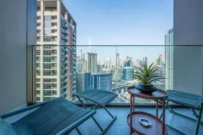 a balcony with chairs and a table and a view of the city at 2 Bedroom in Peninsula with Burj View in Dubai