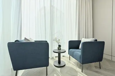 a living room with two chairs and a table at 2BD Stylish Apartment with Amazing Canal Views in Dubai