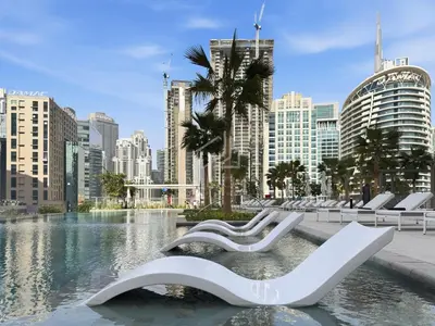 a group of white benches in a city with buildings at 2BD Stylish Apartment with Amazing Canal Views in Dubai