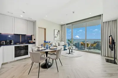 a kitchen and living room with a table and chairs at 2BD Stylish Apartment with Amazing Canal Views in Dubai