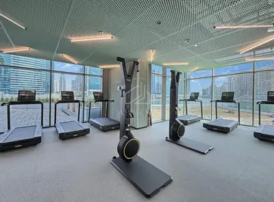 a gym with treadmills and ellipticals in a building at 2BD Stylish Apartment with Amazing Canal Views in Dubai