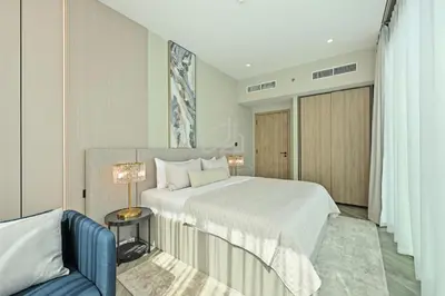 a bedroom with a large bed and a blue couch at 2BD Stylish Apartment with Amazing Canal Views in Dubai