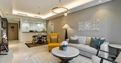 a living room with a couch and a table at Burj View 2BHK Downtown Infinity Pool in Dubai