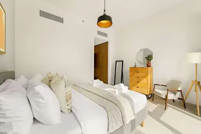 a white bedroom with a bed with white pillows at Silkhaus Elite 3BR near Dubai Watercanal in Al Wasl in Dubai