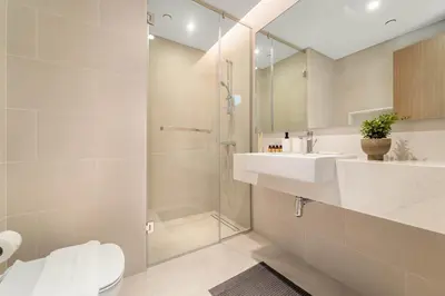 a bathroom with a shower and a toilet and a sink at Silkhaus Elite 3BR near Dubai Watercanal in Al Wasl in Dubai