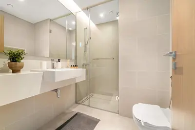 a bathroom with a shower and a sink and a toilet at Silkhaus Elite 3BR near Dubai Watercanal in Al Wasl in Dubai
