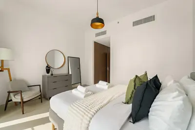a white bedroom with a bed and a mirror at Silkhaus Elite 3BR near Dubai Watercanal in Al Wasl in Dubai