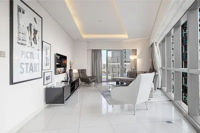 a living room with white tile flooring and a living room with white furniture at PNB Living - Luxury 2 Bedroom Apartment with High Floor - DAMAC Towers by Paramount Tower D in Dubai