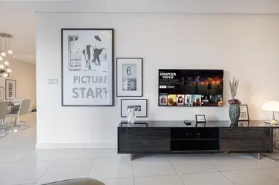 a living room with a tv on a white wall at PNB Living - Luxury 2 Bedroom Apartment with High Floor - DAMAC Towers by Paramount Tower D in Dubai