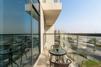 a balcony with two tables and a view of a street at Beautiful 2BR at Majestique Residence Dubai South in Dubai