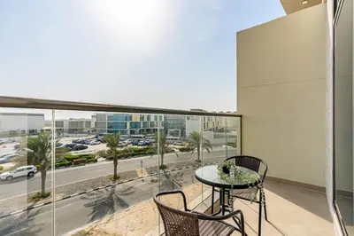 a balcony with a table and chairs and a view of a street at Beautiful 2BR at Majestique Residence Dubai South in Dubai