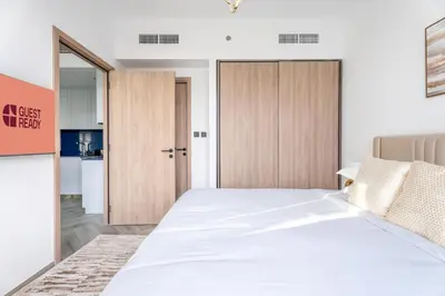 a bedroom with a large bed and a kitchen at GuestReady - 1BR l Burj Khalifa View in Dubai