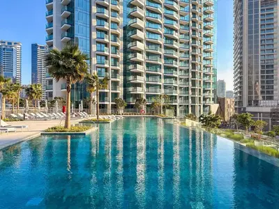 a large swimming pool in front of a tall building at GuestReady - 1BR l Burj Khalifa View in Dubai