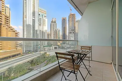 a balcony with a table and chairs and a view of a city at Silkhaus Studio Stay in Dubai Marina - Botanica in Dubai