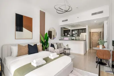 a bedroom with a white bed and a living room at Silkhaus Studio Stay in Dubai Marina - Botanica in Dubai