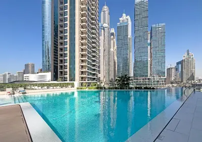 a large swimming pool in a city with tall buildings at LIV Marina, Dubai Marina - 4 Bedroom Penthouse with Panoramic Views - Allsopp & Allsopp in Dubai