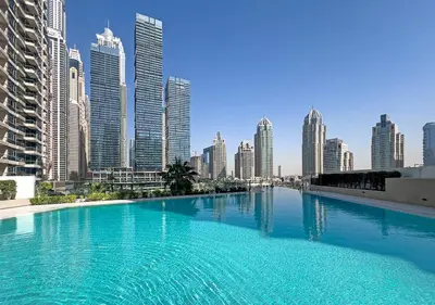 a large swimming pool in a city with tall buildings at LIV Marina, Dubai Marina - 4 Bedroom Penthouse with Panoramic Views - Allsopp & Allsopp in Dubai