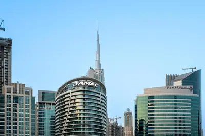 a tall building with a sign on it in a city at GuestReady - Premium Location | Studio | Pool View in Dubai