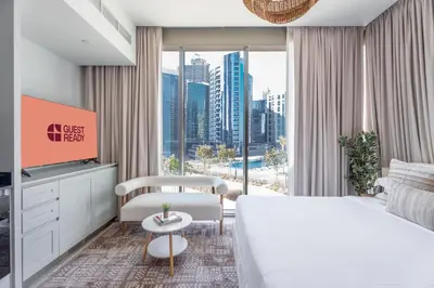 a hotel room with a large bed and a large window at GuestReady - Premium Location | Studio | Pool View in Dubai