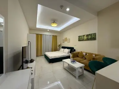 a living room with a couch and a bed at Refined Studio at Dar Al Jawhara in Dubai