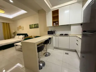 a kitchen with a counter top and a living room at Refined Studio at Dar Al Jawhara in Dubai