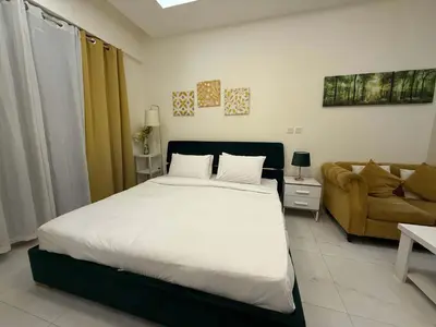 a bedroom with a large bed and a couch at Refined Studio at Dar Al Jawhara in Dubai
