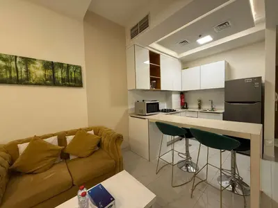 a living room with a couch and a kitchen at Refined Studio at Dar Al Jawhara in Dubai