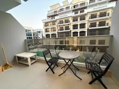 a balcony with a table and chairs and a building at Refined Studio at Dar Al Jawhara in Dubai