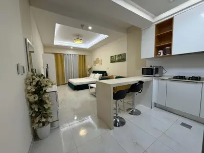 a kitchen and a living room with a couch at Refined Studio at Dar Al Jawhara in Dubai