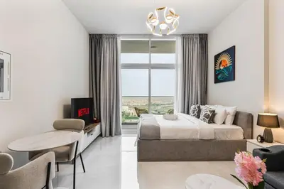a bedroom with a bed and a living room at Chic Studio near Dubai Miracle Garden & Expo City in Dubai