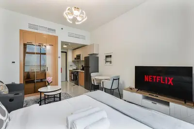 a bedroom with a large bed and a kitchen at Chic Studio near Dubai Miracle Garden & Expo City in Dubai