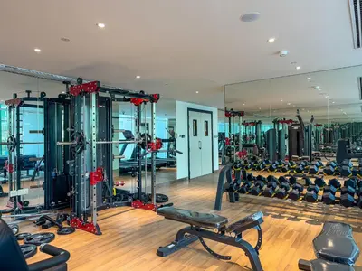 a gym with rows of treadmills and machines at Chic Studio near Dubai Miracle Garden & Expo City in Dubai