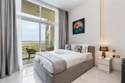 a bedroom with a large bed and a large window at Chic Studio near Dubai Miracle Garden & Expo City in Dubai