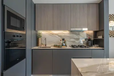 a kitchen with a sink and a stove at 1BR Sunlit Modern Retreat with Private Sunbeds in Dubai