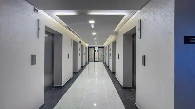 a hallway of an office building with white walls and ceilings at Peaceful High-Rise Studio Overlooking Miracle Garden, Skyz by Danube, Arjan by Deluxe Holiday Homes in Dubai
