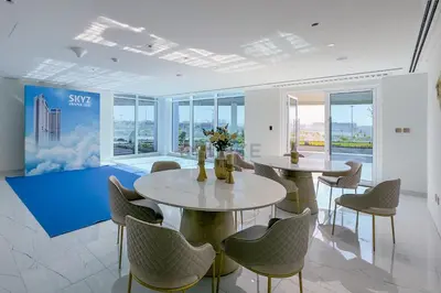 two tables and chairs in a room with windows at Peaceful High-Rise Studio Overlooking Miracle Garden, Skyz by Danube, Arjan by Deluxe Holiday Homes in Dubai