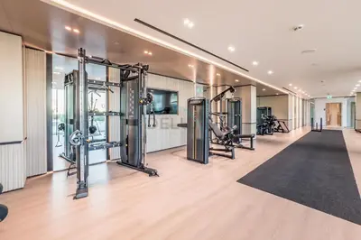 a gym with several treadmills and machines at Well-Appointed Studio, Minutes from Circle Mall and Community Parks - Binghatti Phoenix, Jumeirah Village Circle by Deluxe Holiday Homes in Dubai