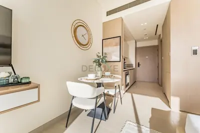 a kitchen and dining room with a table and chairs at Well-Appointed Studio, Minutes from Circle Mall and Community Parks - Binghatti Phoenix, Jumeirah Village Circle by Deluxe Holiday Homes in Dubai