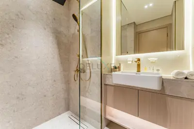 a bathroom with a sink and a glass shower at Well-Appointed Studio, Minutes from Circle Mall and Community Parks - Binghatti Phoenix, Jumeirah Village Circle by Deluxe Holiday Homes in Dubai