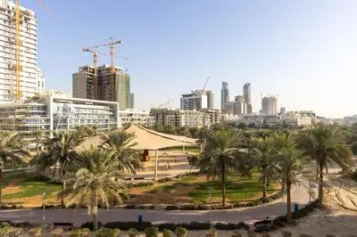 a view of a city with palm trees and buildings at Contemporary 2BR in JVC With Pool, Gym & Relaxing Stay in Dubai