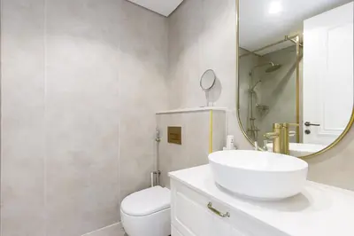 a bathroom with a sink and a toilet and a mirror at Contemporary 2BR in JVC With Pool, Gym & Relaxing Stay in Dubai