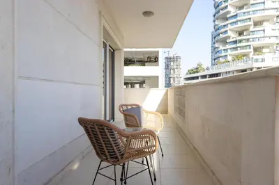 two chairs sitting on the balcony of a building at Contemporary 2BR in JVC With Pool, Gym & Relaxing Stay in Dubai